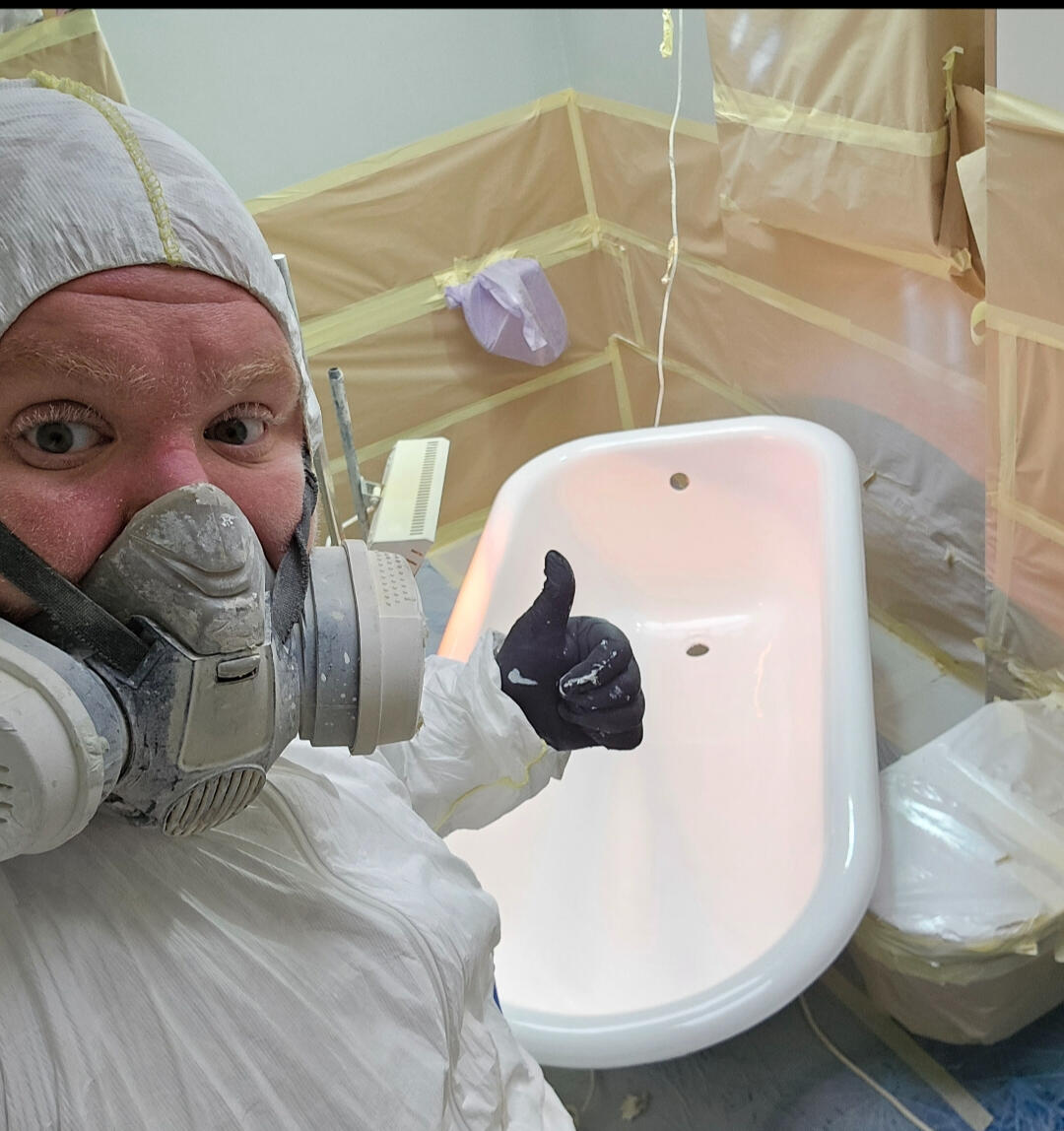 photo of glossy baths owner photo of glossy baths re-enamelling owner Seamus with a thumbs up, in ppe, in a room full of masking up and a completed bath in Somerset